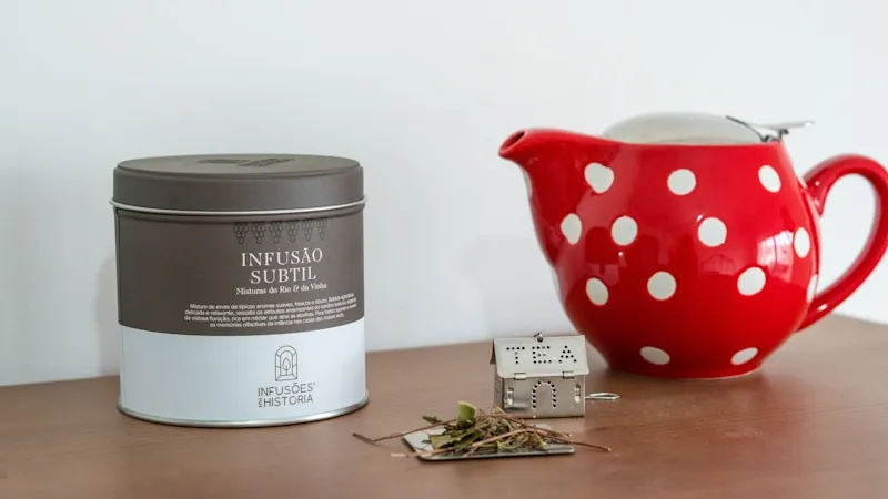 A teapot beside a tin of aging tea